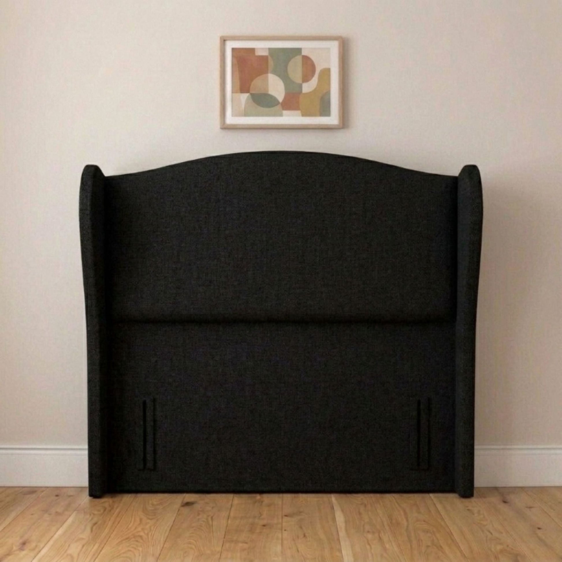 Wingback upholstered headboard close-up of cream fabric and winged edge